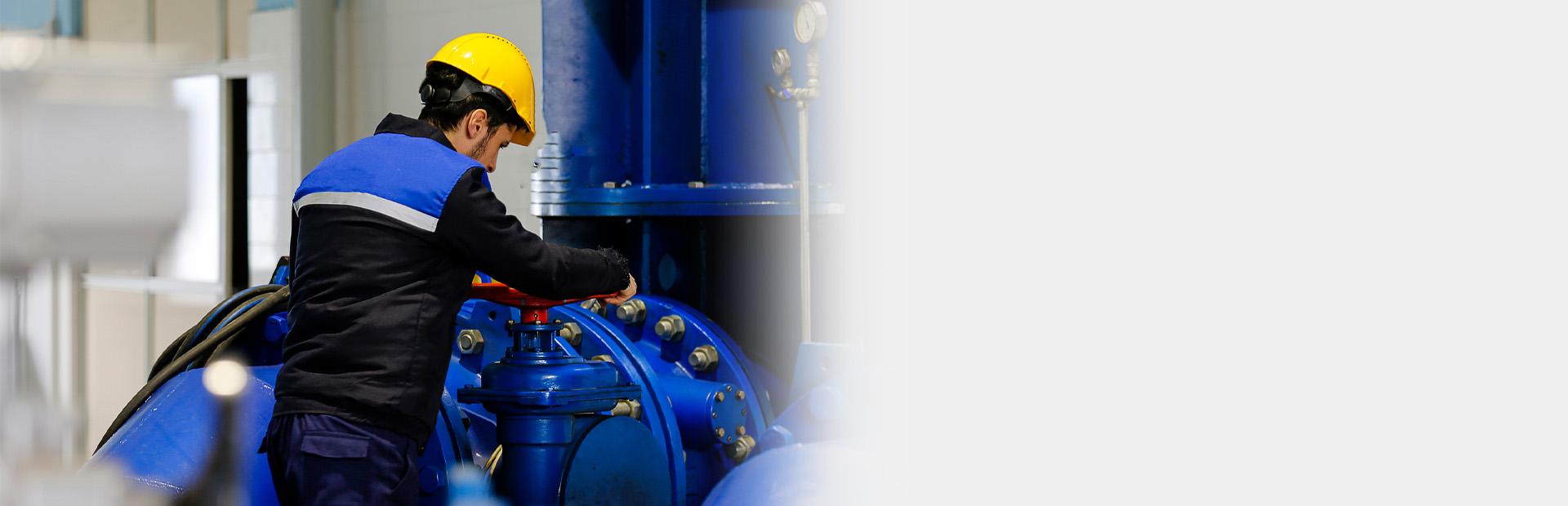 Mężczyzna zakręcający duży zawór - Slajd 1